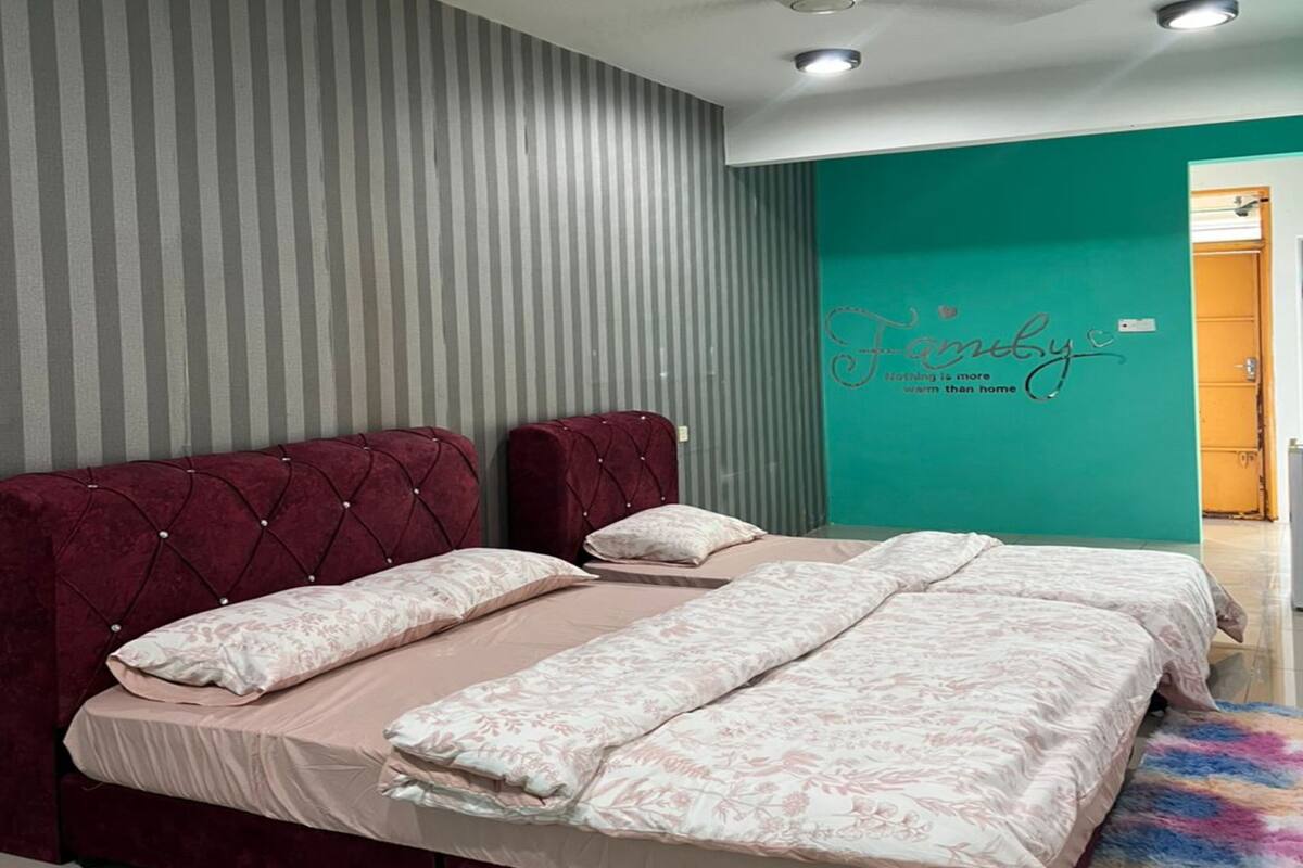 A bedroom with a bed, striped wallpaper, a teal accent wall, and a ceiling fan.