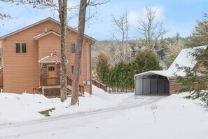 A two-story house with a front porch and a garage. - 4BR Dog Friendly Lakefront | Private Dock, Fireplace, Sleeps 8, Near Gunstock (Gilmanton)