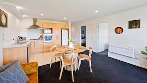 A modern apartment with a kitchen, dining area, and living room.