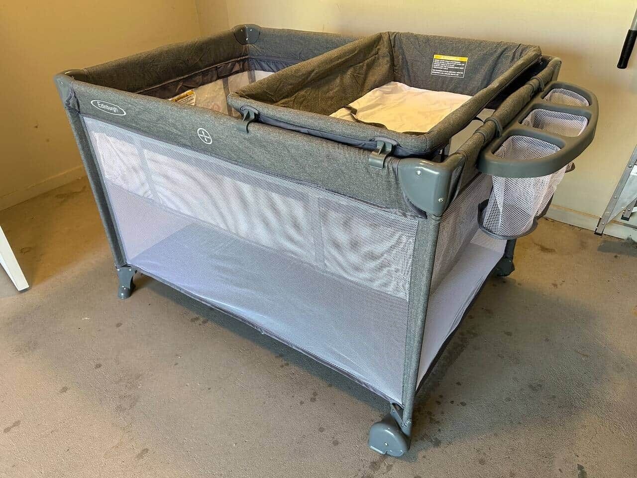 A portable storage unit with a mesh front, wheels, and a handle.