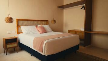 Un dormitorio ordenado con cama, mesitas de noche y una lámpara colgante.