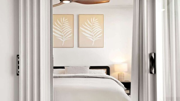 A bedroom with a bed, a nightstand with a lamp, and two wall-mounted leaf-patterned artworks. - Balcony Views, Parking, Pool & Gym | Walk to CBD (Spring Hill)