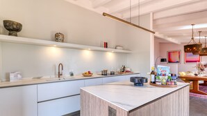 A modern kitchen with white cabinetry, a marble island, and a dining area with a table and chairs. - Villa Belvedere Condor  - S, Alassio, Italy (Alassio)