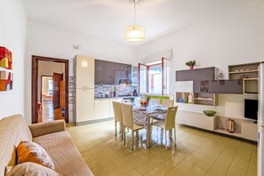Eine moderne Küche mit Essbereich, einer Couch und einem Fernseher.