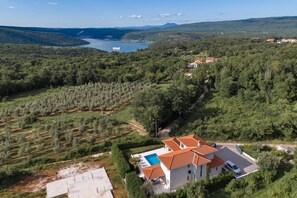 A residential property with a swimming pool, surrounded by olive groves and a view of a lake. - Pool Villa Ora in Nature, Rakalj, Croatia (Rakalj)