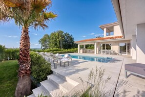 A modern house with a swimming pool, outdoor seating, and a view of the sea. - Pool Villa Ora in Nature, Rakalj, Croatia (Rakalj)