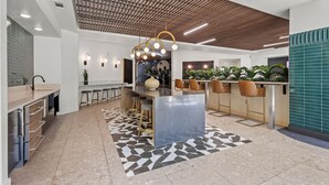 A modern kitchen with a central island, bar stools, and pendant lighting.