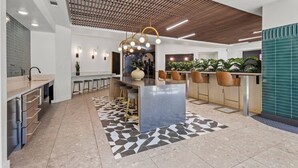 Una cocina moderna con una isla central, taburetes de bar e iluminación colgante.