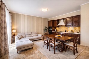 A modern living room with a sofa, a dining table with chairs, and a kitchen area with wooden cabinets and appliances. - Duplex Le Onde - Center & Parking, Ceriale, Italy (Ceriale)