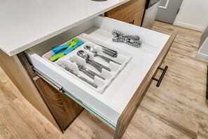 Eine Schublade mit Küchenutensilien und einem Salatbesteck.