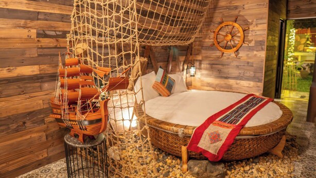 A cozy room with a bed, a ship model, and a wooden wall. - Luong Son Retreat (Luong Son)