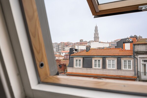 A view from a window overlooking a cityscape with a prominent tower in the background. - GuestReady - charming studio in Porto's heart (Porto)