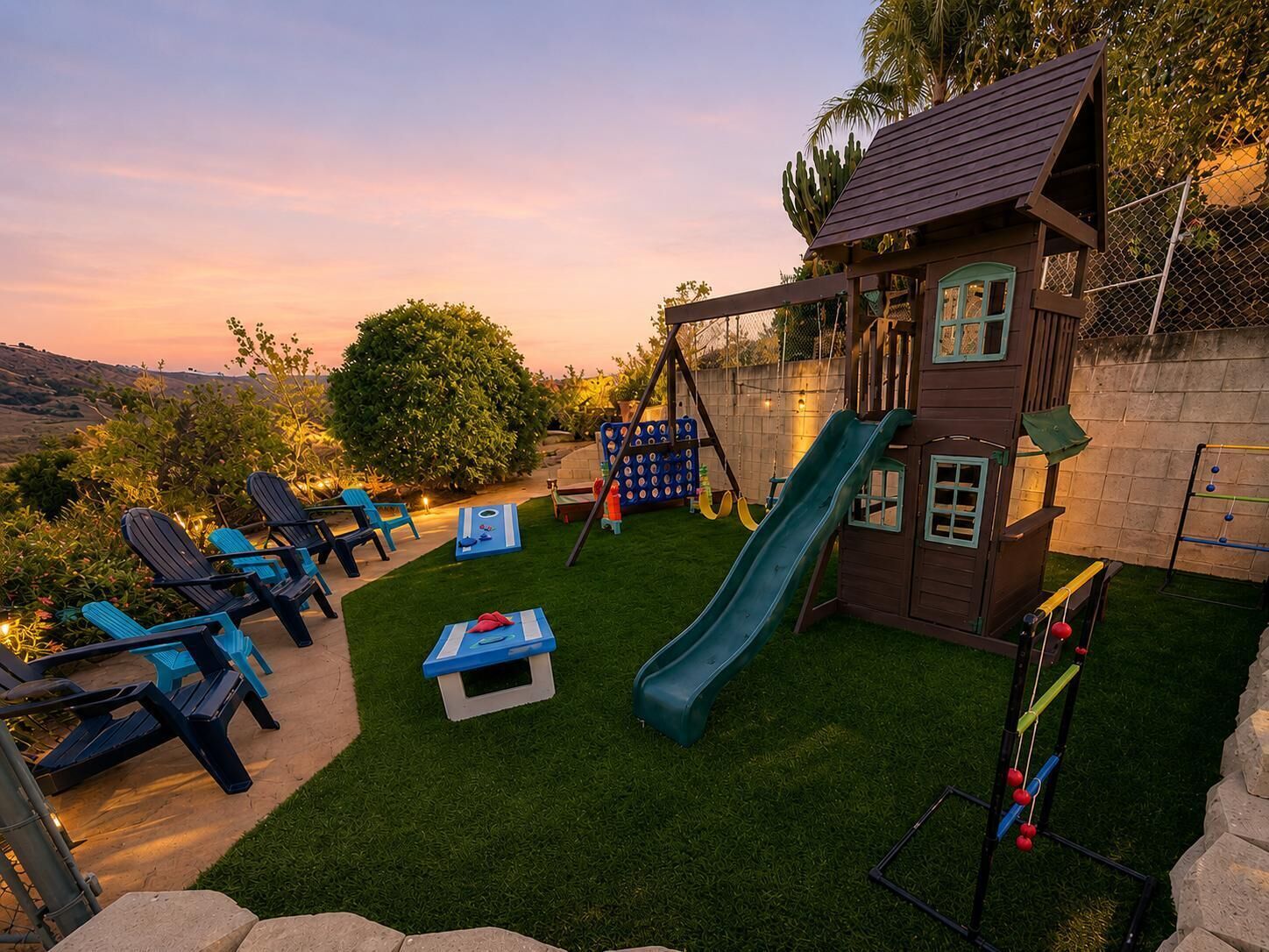 Un patio trasero con una casita de juegos, un tobogán y mobiliario de exterior.