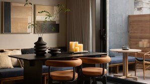 A modern interior with a dining area, a sofa, and a view of traditional architecture outside. - AnHeANAHATA (Datong)
