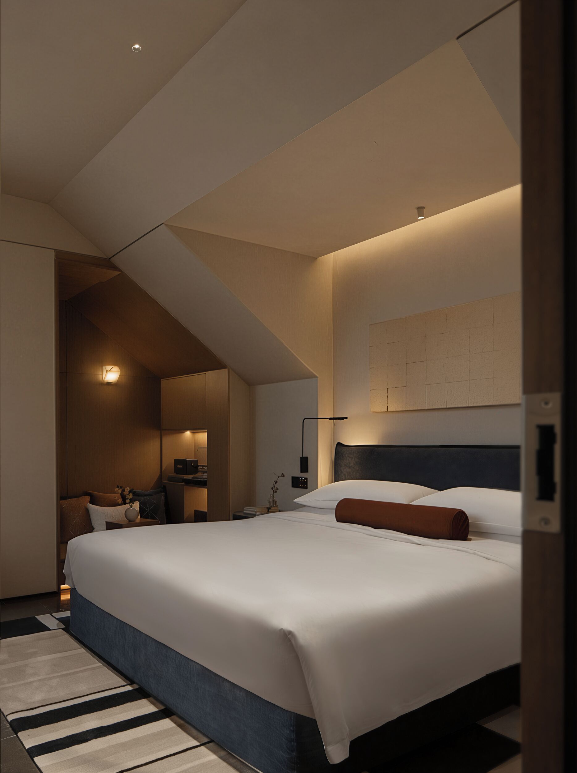 Et moderne hotelværelse med en stor seng, et skrivebord og et siddeområde.