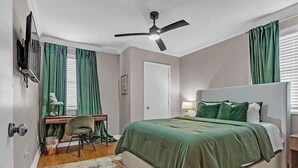 A bedroom with a bed, desk, chair, and a ceiling fan. - Olive Midtown Retreat Walkable, Stylish & Central (Memphis)