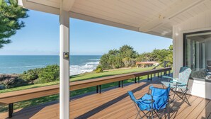 A covered outdoor area with a wooden deck, a bench, and a view of the ocean. - Pacific Seascape - An ocean front gem on the Mendocino coast! (Albion)
