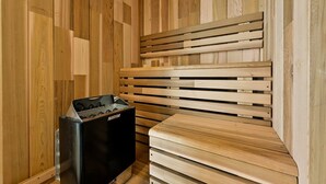Una sauna con bancos de madera y un calentador negro con la etiqueta 'HARVIA'.