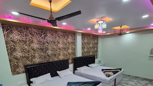 Ein Schlafzimmer mit zwei Betten, einem Deckenventilator und einer Wandverzierung.