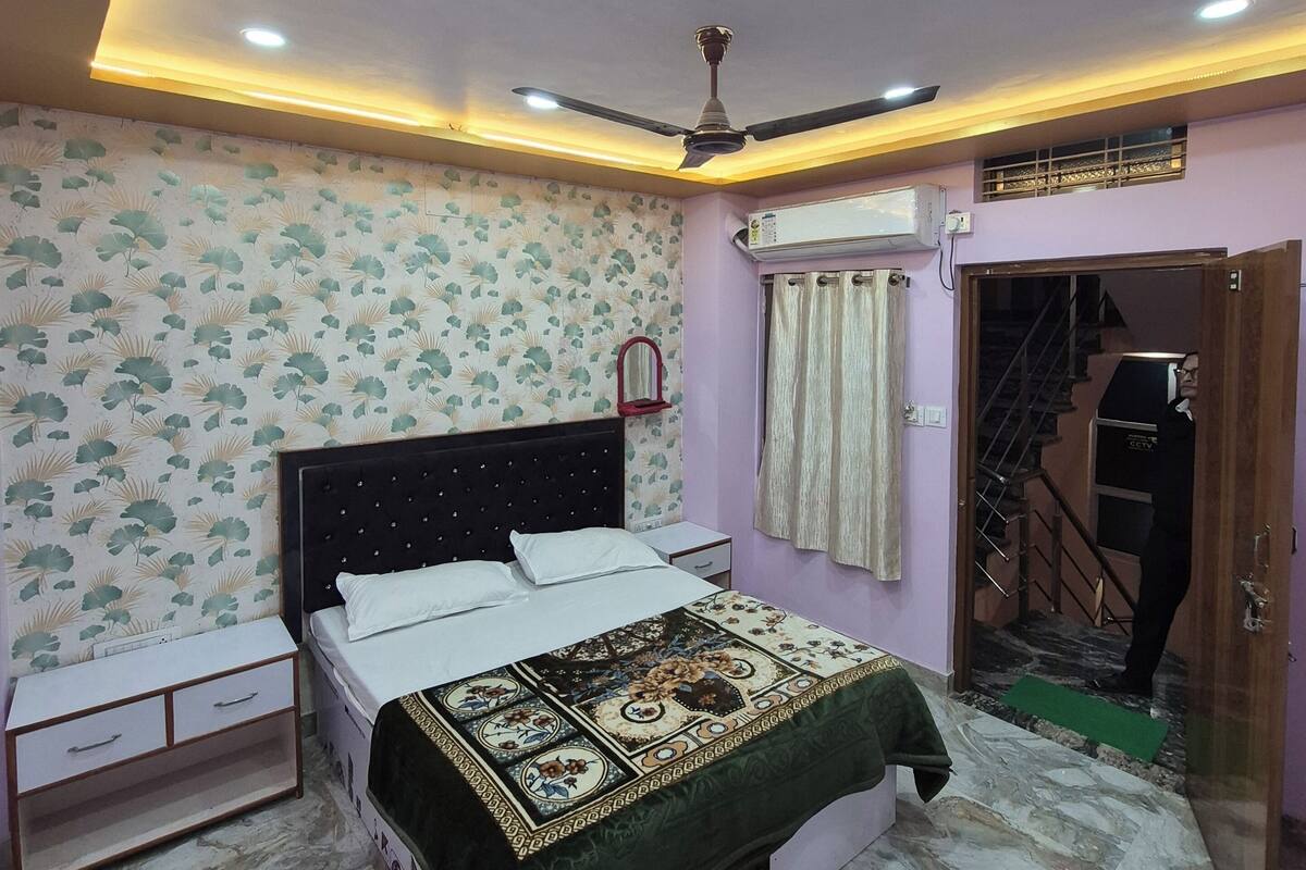 A bedroom with a bed, nightstand, and a ceiling fan.