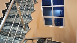 Eine Treppe mit Metallgeländer und einem Fenster mit vier Fensterscheiben.