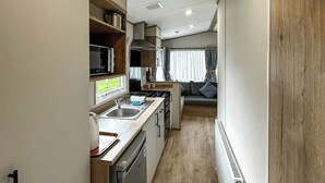 Una cucina compatta con lavastoviglie, microonde e piano cottura.