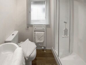 A bathroom with a toilet, a bathtub, a shower, and a towel rack. - Goscar 1 The Saltern Holiday Park - UKC8209 (Tenby)