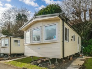 A mobile home with a front porch, a garage, and a small attached structure. - Goscar 1 The Saltern Holiday Park - UKC8209 (Tenby)