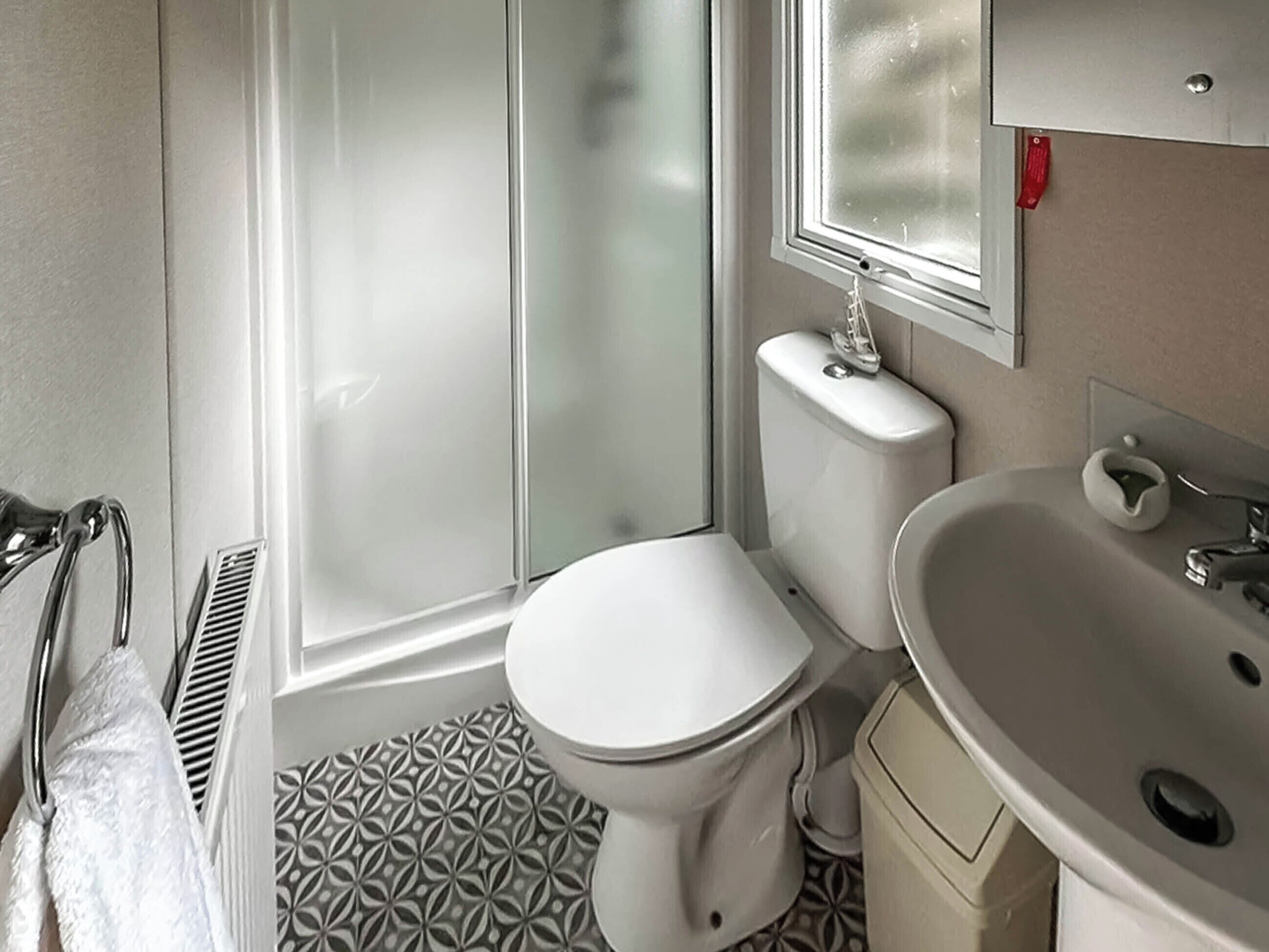Ein Badezimmer mit Toilette, Waschbecken und Duschbereich.