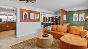 A modern living room with a sectional sofa, a coffee table, and artwork on the walls.