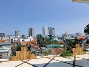 Une terrasse sur le toit offrant une vue panoramique sur la ville, avec ses gratte-ciel et ses espaces verts.