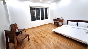 A room with a bed, a desk, and a chair. - Top Hill Halong Homestay (Bai Chay)