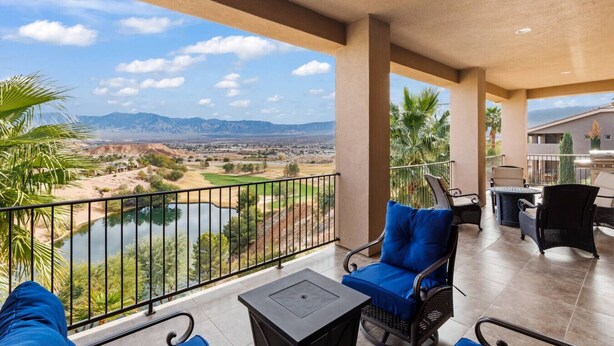 A balcony with a view of a golf course and mountains.
