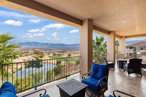 A balcony with a view of a golf course and mountains.