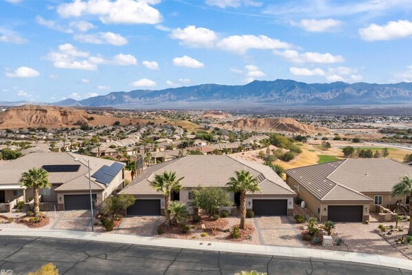 A residential area with houses featuring flat roofs, solar panels, and landscaped gardens.