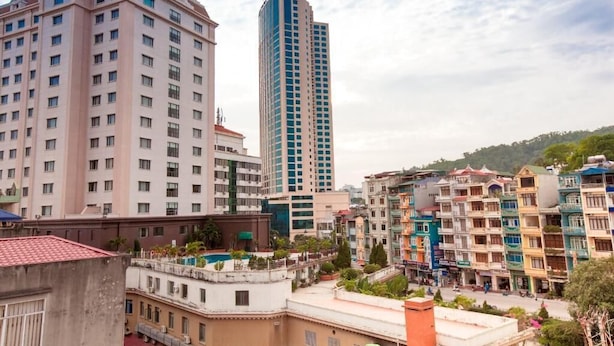 A multi-story building with a modern design, featuring a prominent central tower and several smaller buildings around it. - Alex Halong Hotel & Hostel (Bai Chay)