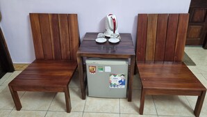 A room with two wooden chairs and a small table with a refrigerator. - Alex Halong Hotel & Hostel (Bai Chay)