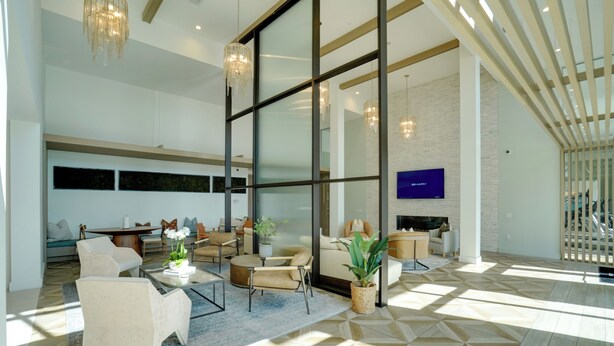 A spacious living area with a large window, a flat-screen TV, and a modern chandelier. - Pool Access! Luxe Condo 7 Mi to Coquina Beach (Bradenton)