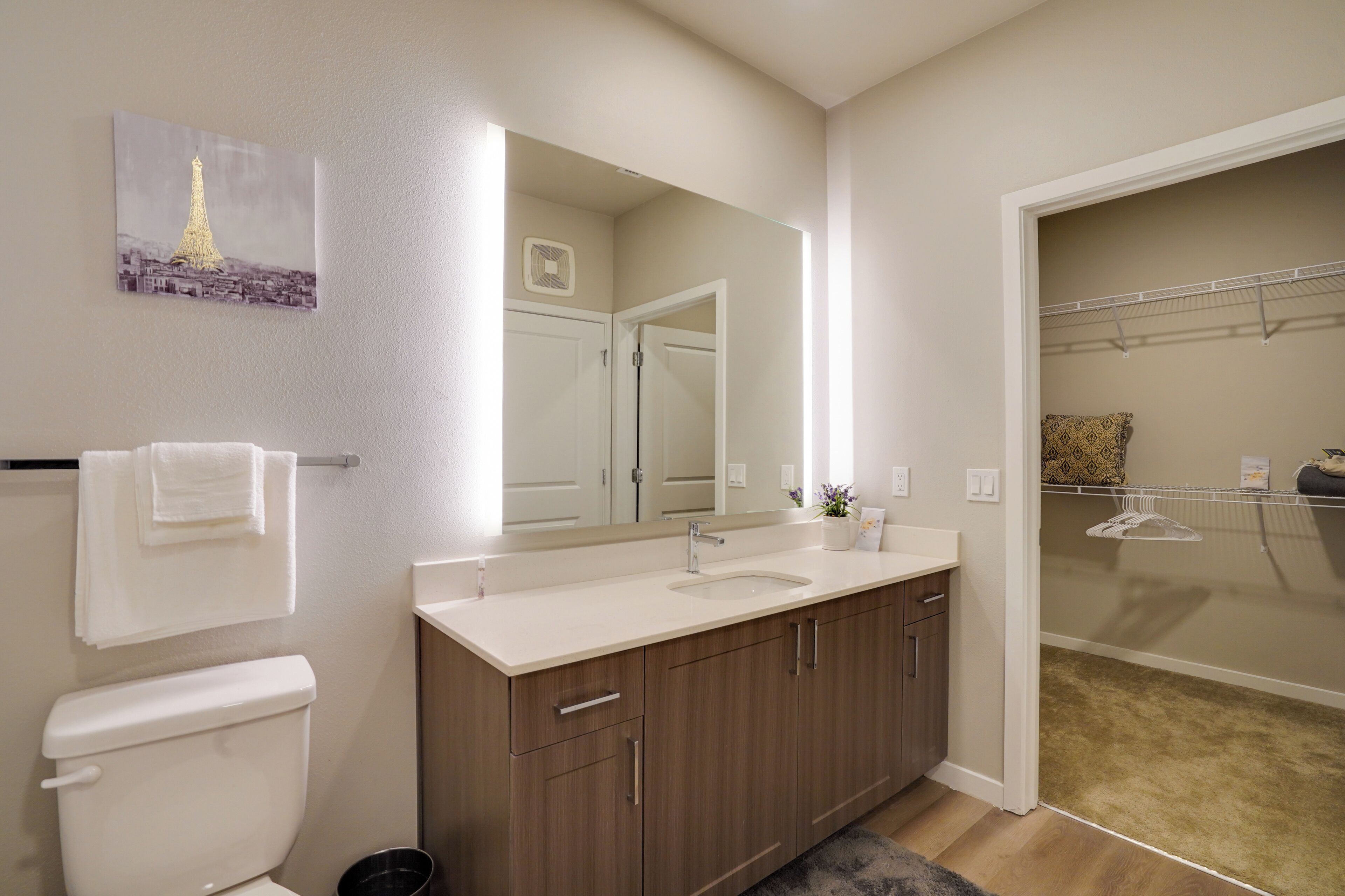 A modern bathroom with a toilet, sink, and mirror.