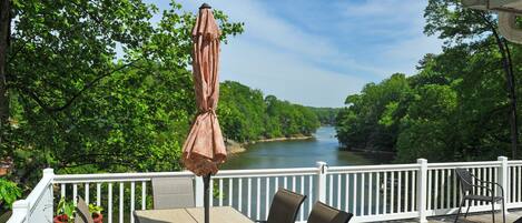 Eine Terrasse mit Tisch und Stühlen mit Blick auf einen Fluss.