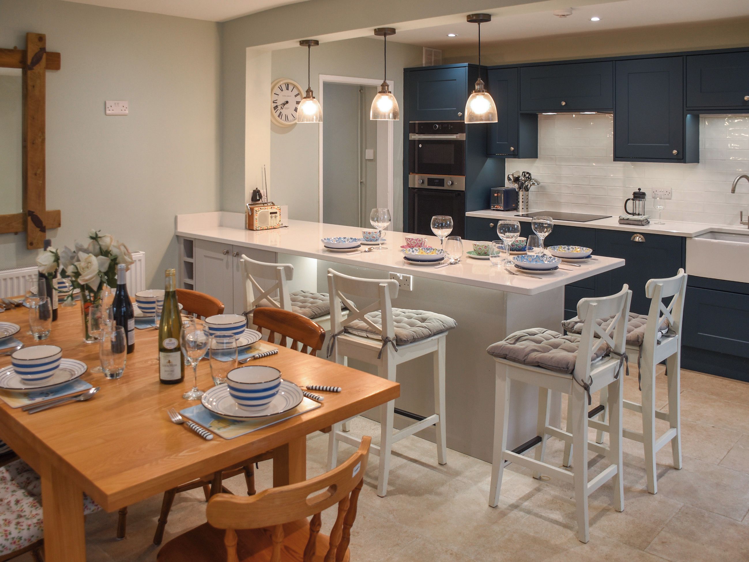 A modern kitchen with a central island, white cabinetry, and pendant lighting.
