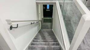 Eine Treppe mit Handlauf und einer Glastür zu einem anderen Raum.