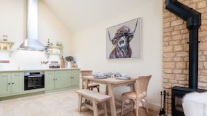 Una cocina con comedor, chimenea y pared de piedra.