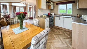A kitchen with a dining area, wooden flooring, and a view of the outdoors. - 2 bedroom accommodation in Hartshorne (Hartshorne)