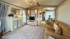 A living room with a sofa, television, and fireplace. - 2 bedroom accommodation in Hartshorne (Hartshorne)