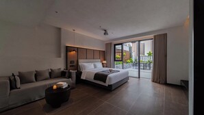 Una habitación de hotel moderna con una cama grande, un sofá, una mesa de centro y un balcón con vistas a la ciudad.