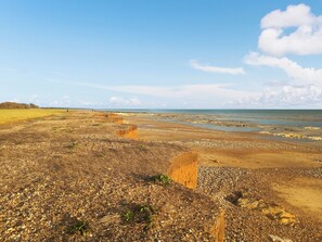 A coastal landscape with a pebbly beach, distant horizon, and a clear sky. - 1 bedroom accommodation in Bognor Regis, near Chichester (Bognor Regis)
