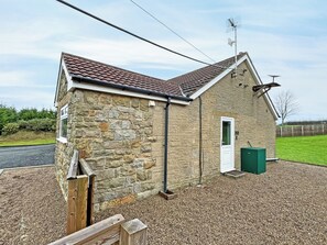 A stone building with a tiled roof, a door, and a small green container. - UK51148 - Clay Hall Farmhouse (Scaling Dam, near Staithes)