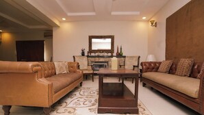 A living room with two leather sofas, a wooden coffee table, and a fireplace.