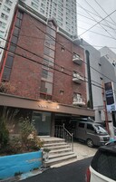 Un edificio con fachada de ladrillo, un cartel que dice 'podohome' y una furgoneta estacionada en la calle.